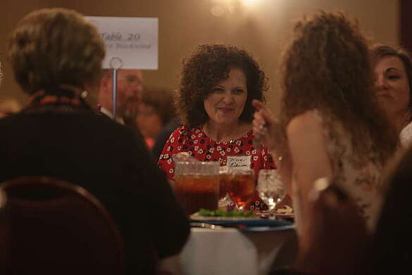 Woman talking with others around a table eating