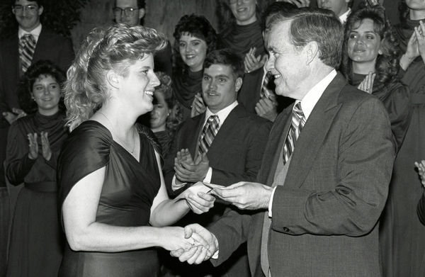 Historical photo of Dr. Wayne Hinds presenting an award to a choir member