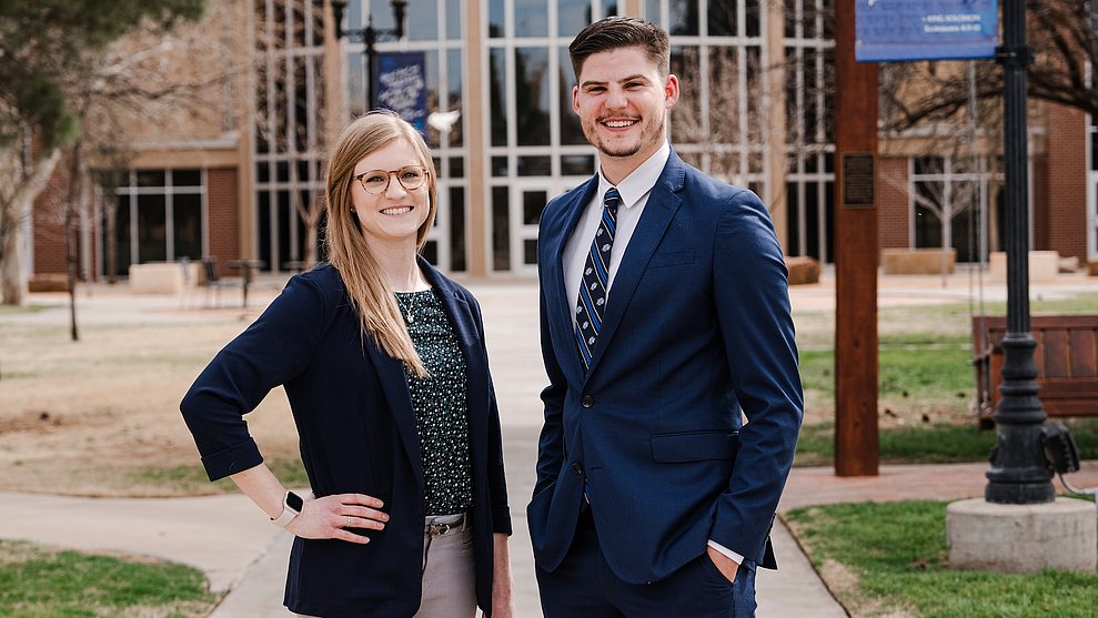 Drs. Haley Burton and Connor Bryant posing outside on LCU's campus