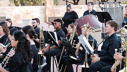 photo of band students performing in front of the fountain