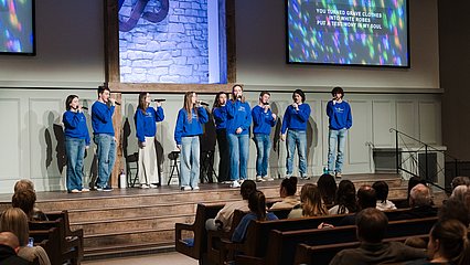 Photograph of LCU's Best Friends singers performing on stage at a church