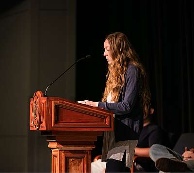 Girl speaking at podium during chapel