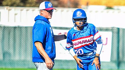 Photograph of Coach Hayes coaching a softball player on the bases