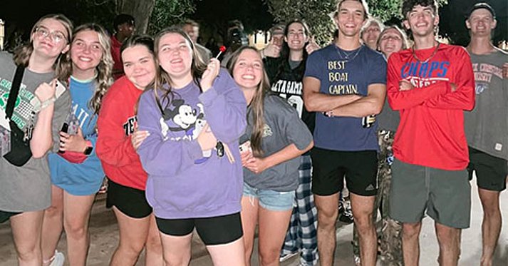 Group of students posing for camera at night
