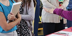 Student Professional Development Student standing in front of a table at a career fair