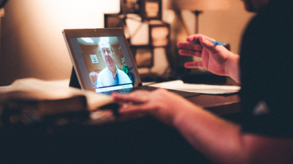 student at laptop, LCU professor on laptop screen