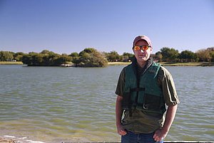 Josh Thomas standing in front of lake