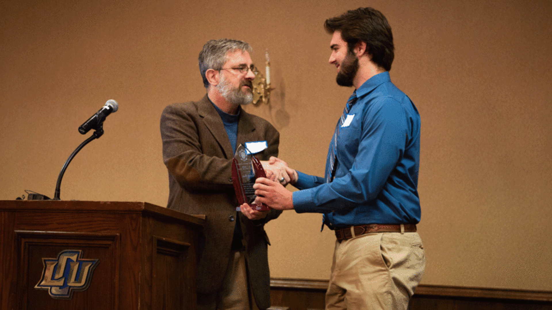 Dr. Brandon Fredenbug presents award to student