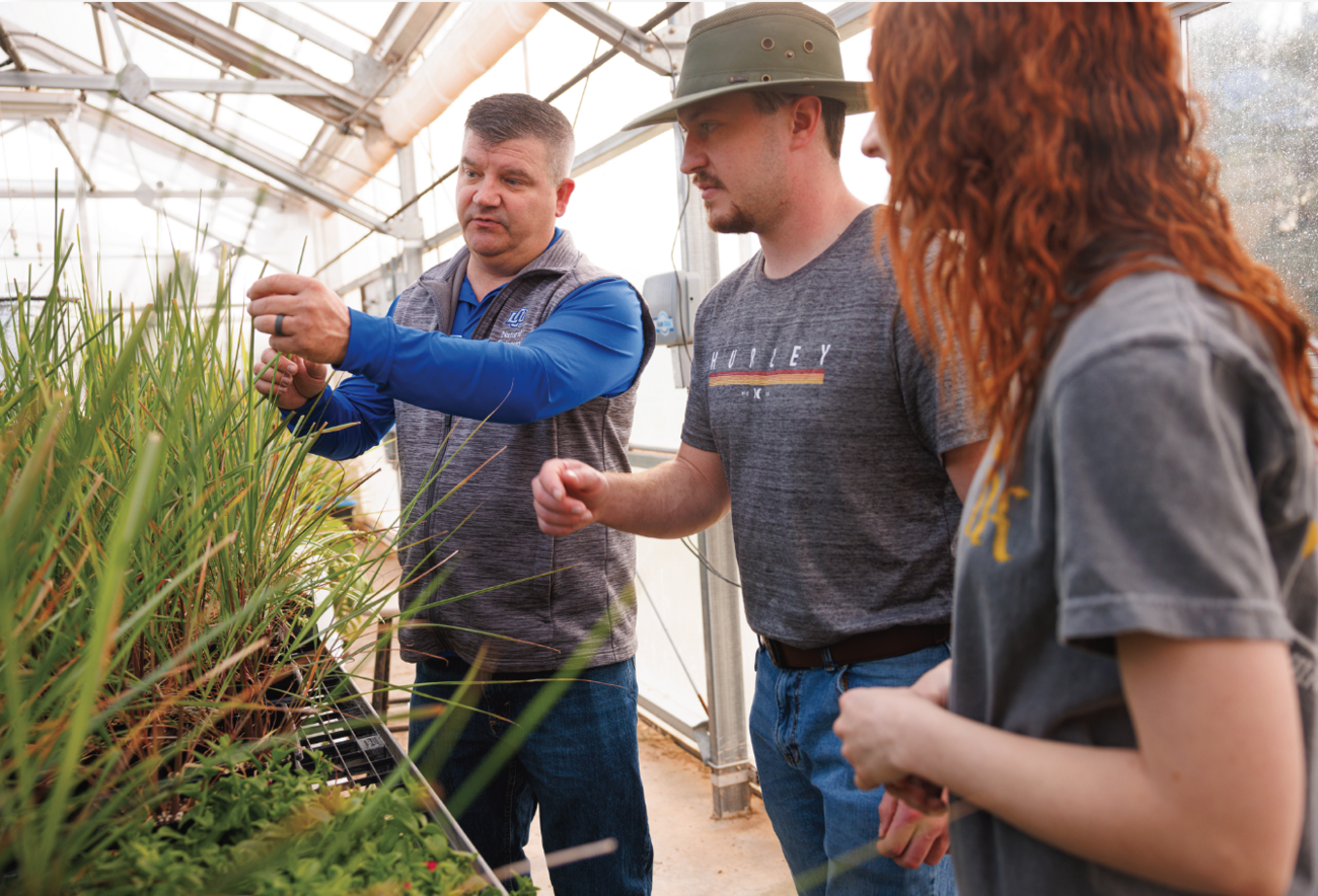 Dr. Laughlin working with student in greenhouse
