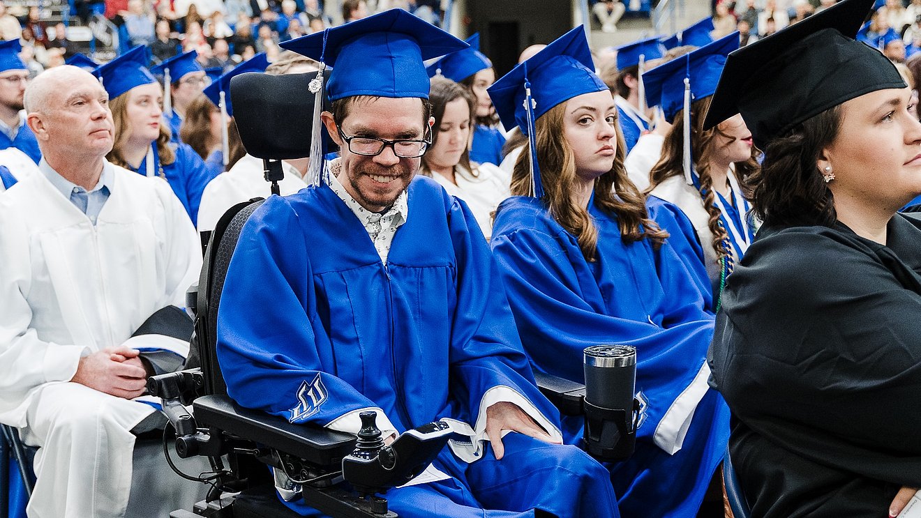 Ben Hooten smiling in graduation regalia at LCU's commencement ceremony