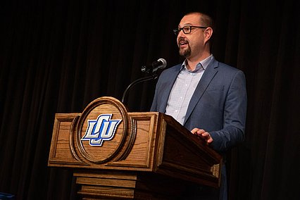 Dr. Jeff Cary speaking from podium on stage