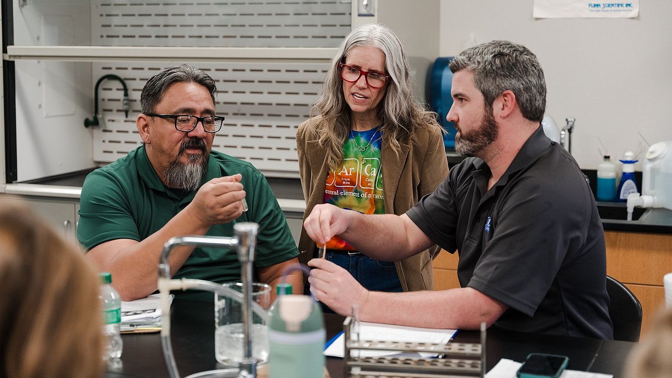 Photograph of Professor Rogers working with two Chemistry teachers during the CHEMTeach Academy