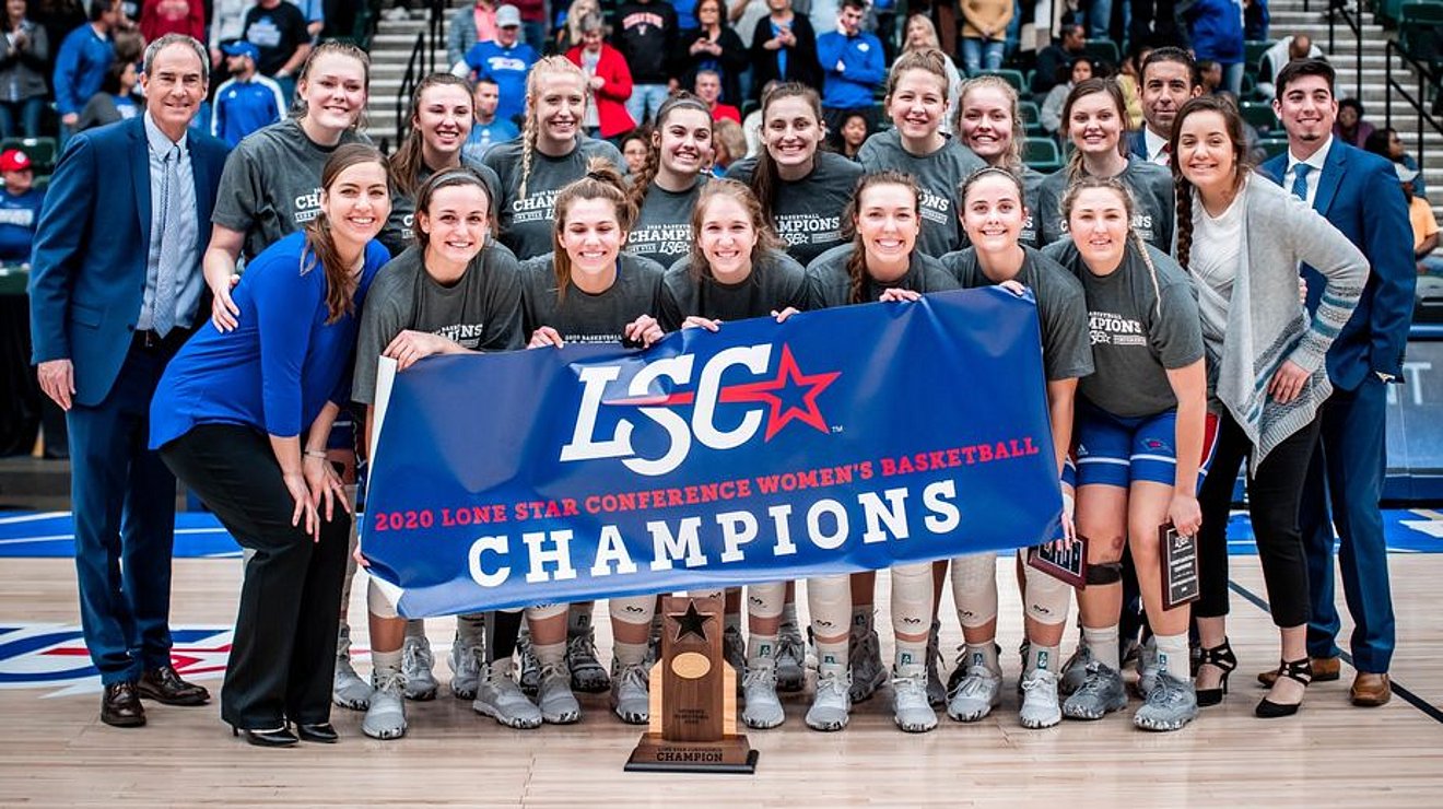 Lady chaps basketball team posing with banner