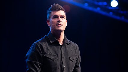 Photograph of Dr. John Delony on stage speaking at LCU in the McDonald Moody Auditorium