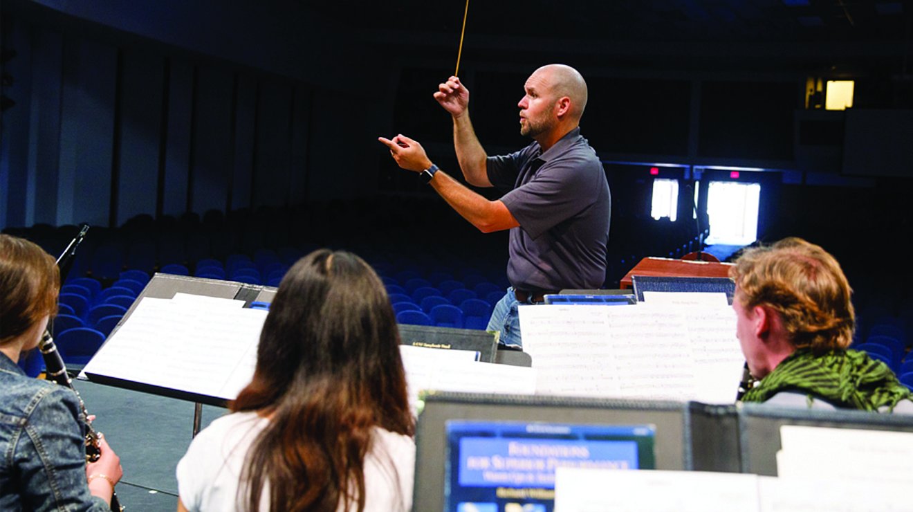 Ryan Smith conducting band on stage