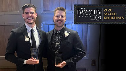 Photograph of Robert Brown and Dr. Connor Bryant holding their 40-Under-40 awards at the Gala