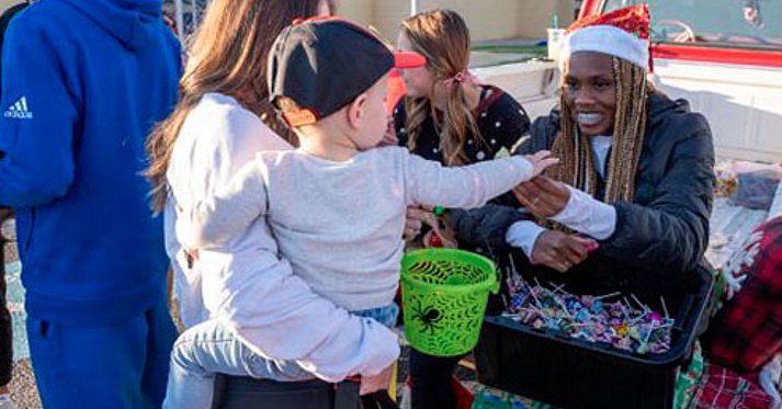 LCU Athlete handing out candy to kid