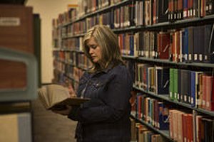 Samantha Lack looking at books in Library