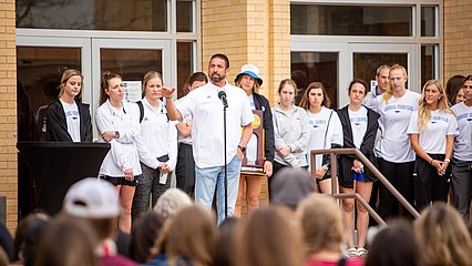 Head Coach Steve Gomez addresses the audience on the Moody steps