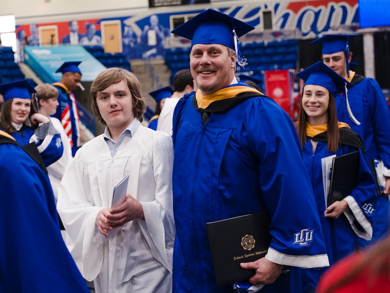 Photograph of non-traditional student graduating with his son escorting him