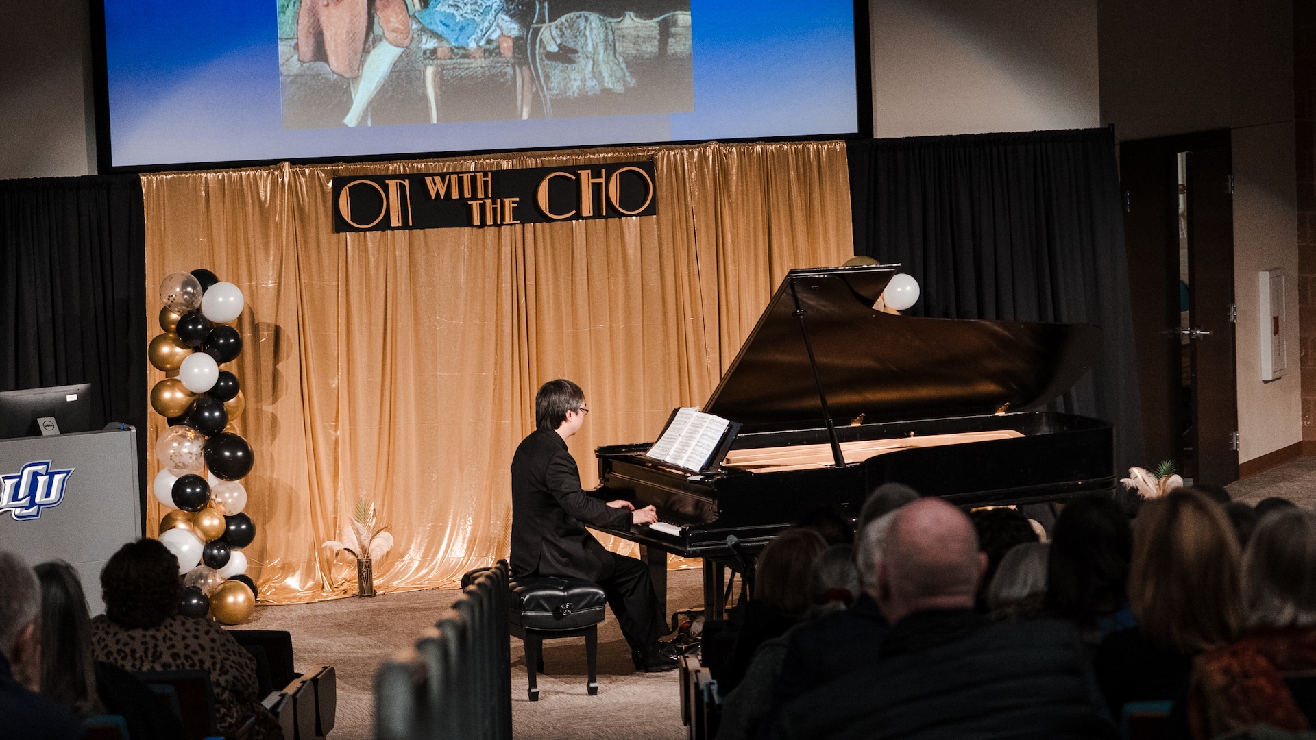 Photograph of Maestro David Cho playing the piano on stage during the event