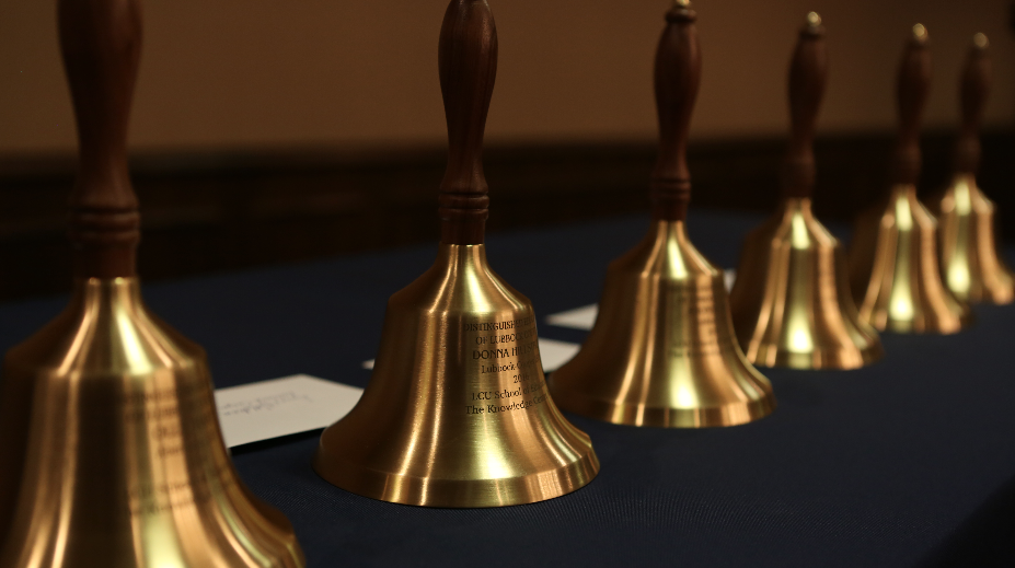 line of inscribed golden bells on table