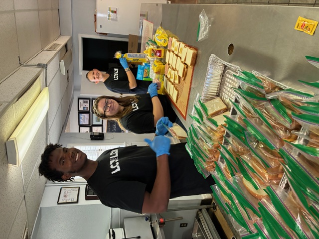 Three LCU students making sandwiches during a service project as a part of LCU 4 LBK