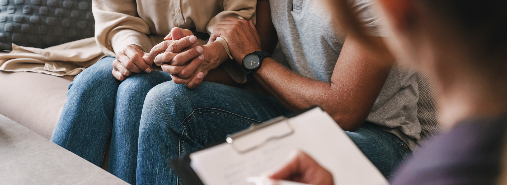 photograph of a couple's hands holding hands in a therapy session