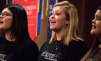 Three ladies singing at the Scholars Colloquium