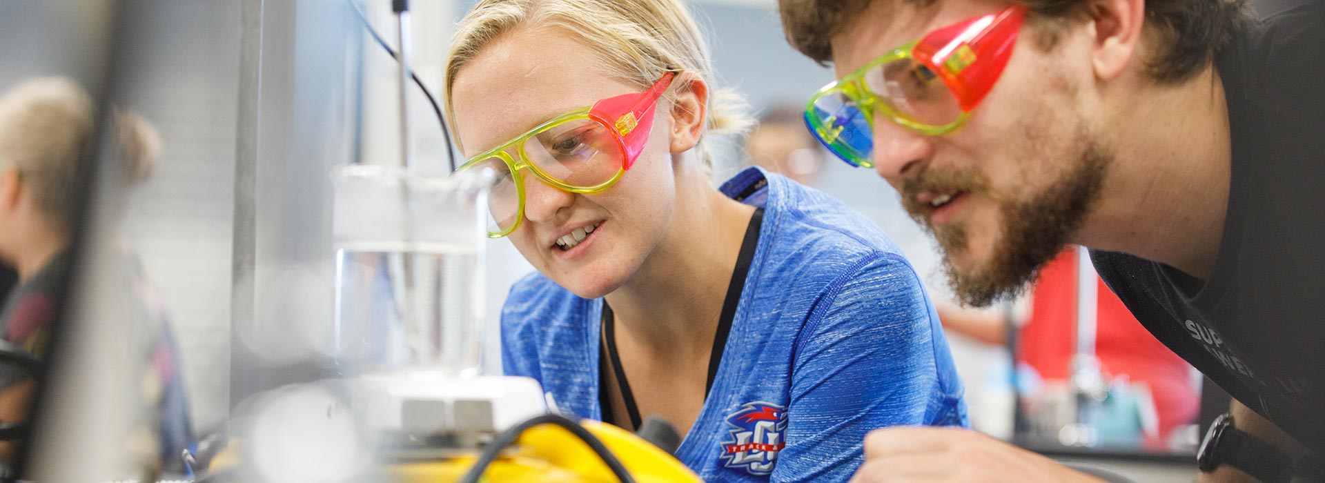 Girl and Boy looking at a chemical reaction on a table