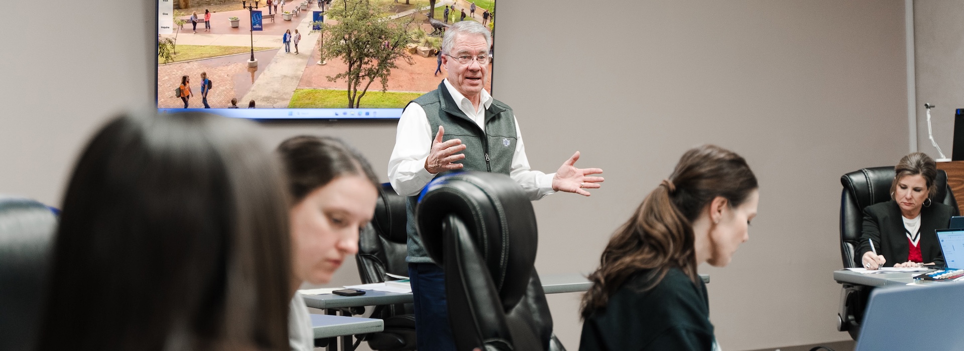 Photo of Dr. Sheets teaching in a room of graduate students