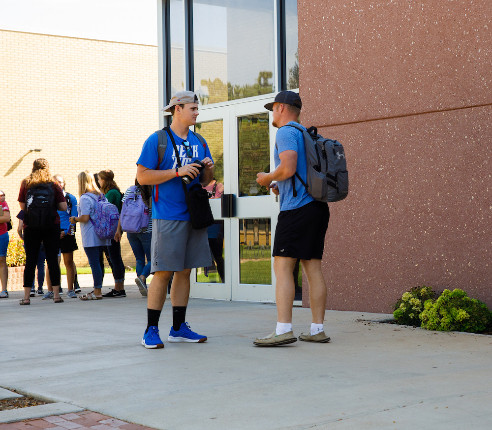 Two guys talking outside the Baker Conference Center